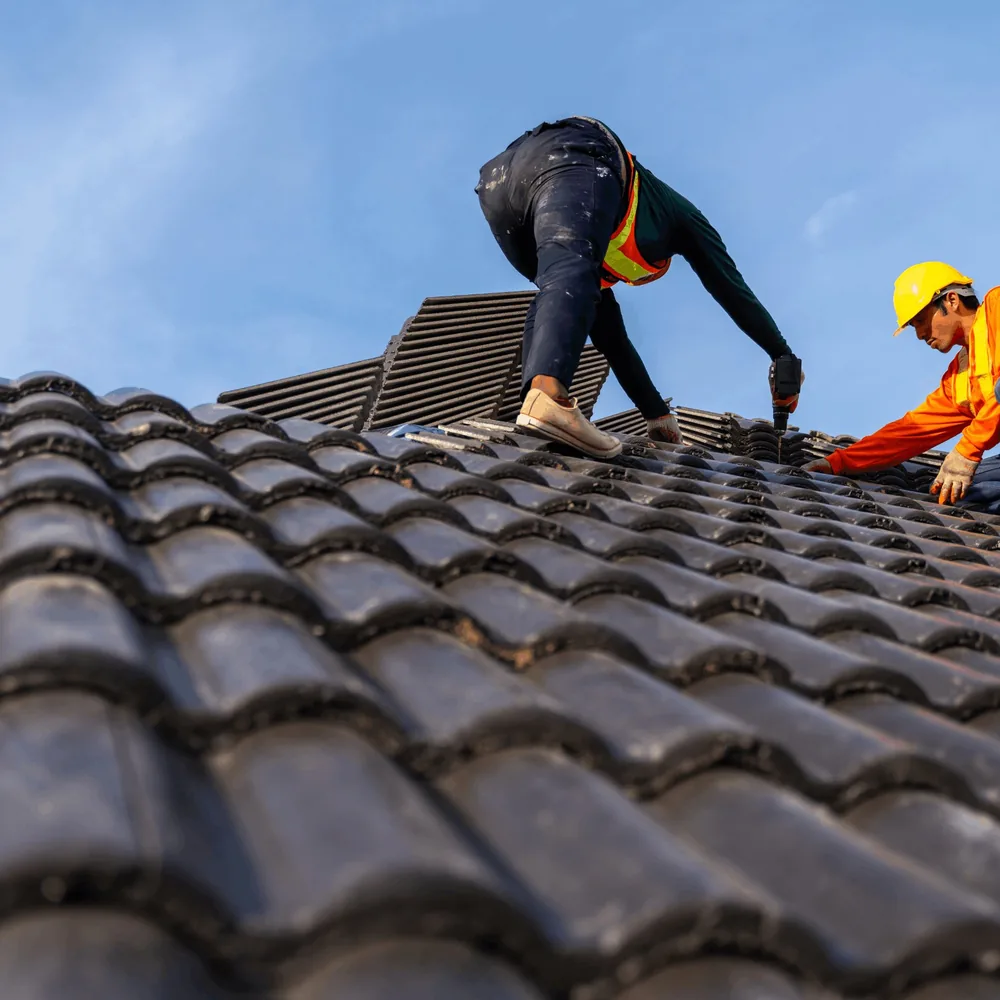 Roof replacement in progress on a brick home with exposed decking