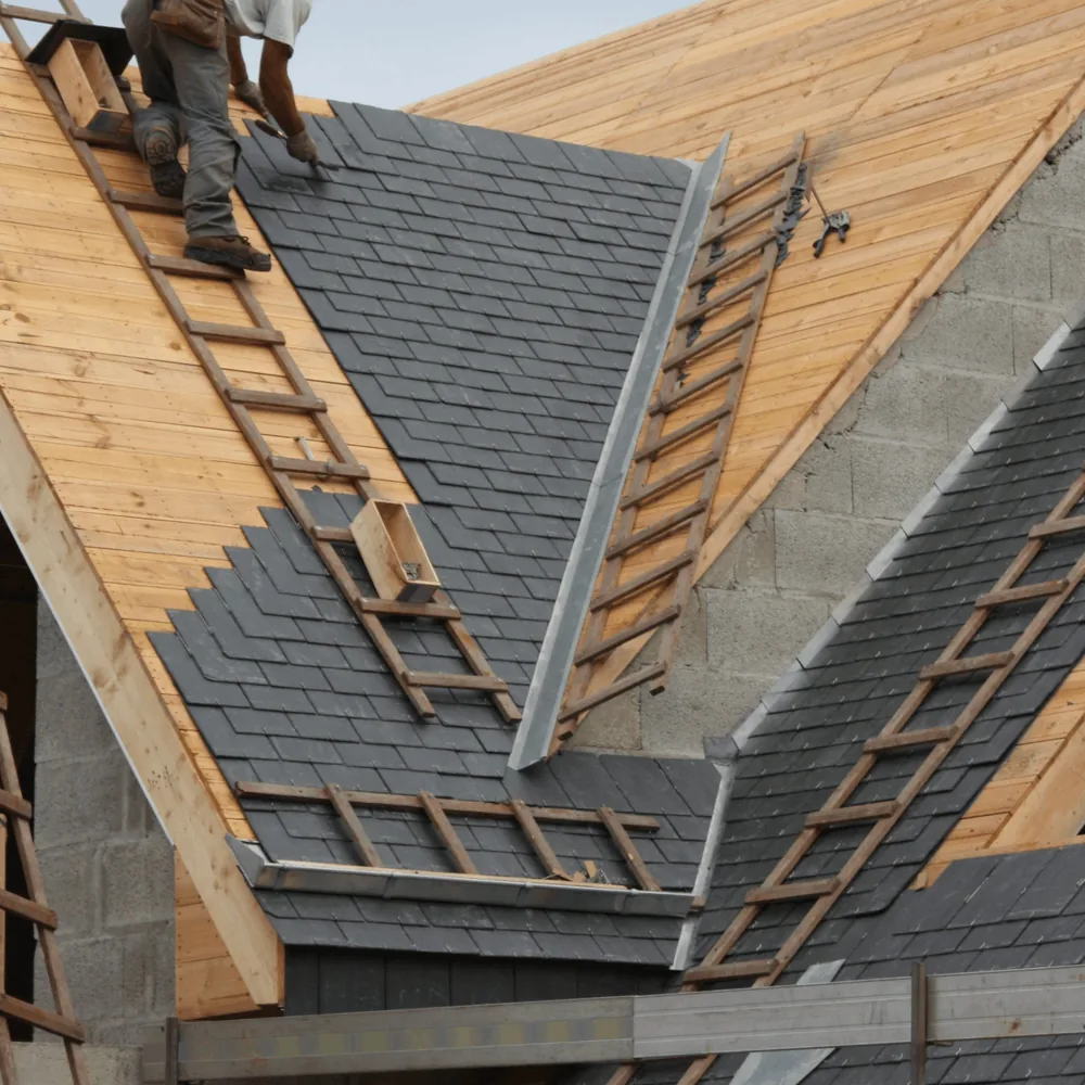 Roofing crew tearing off old shingles during a roof replacement
