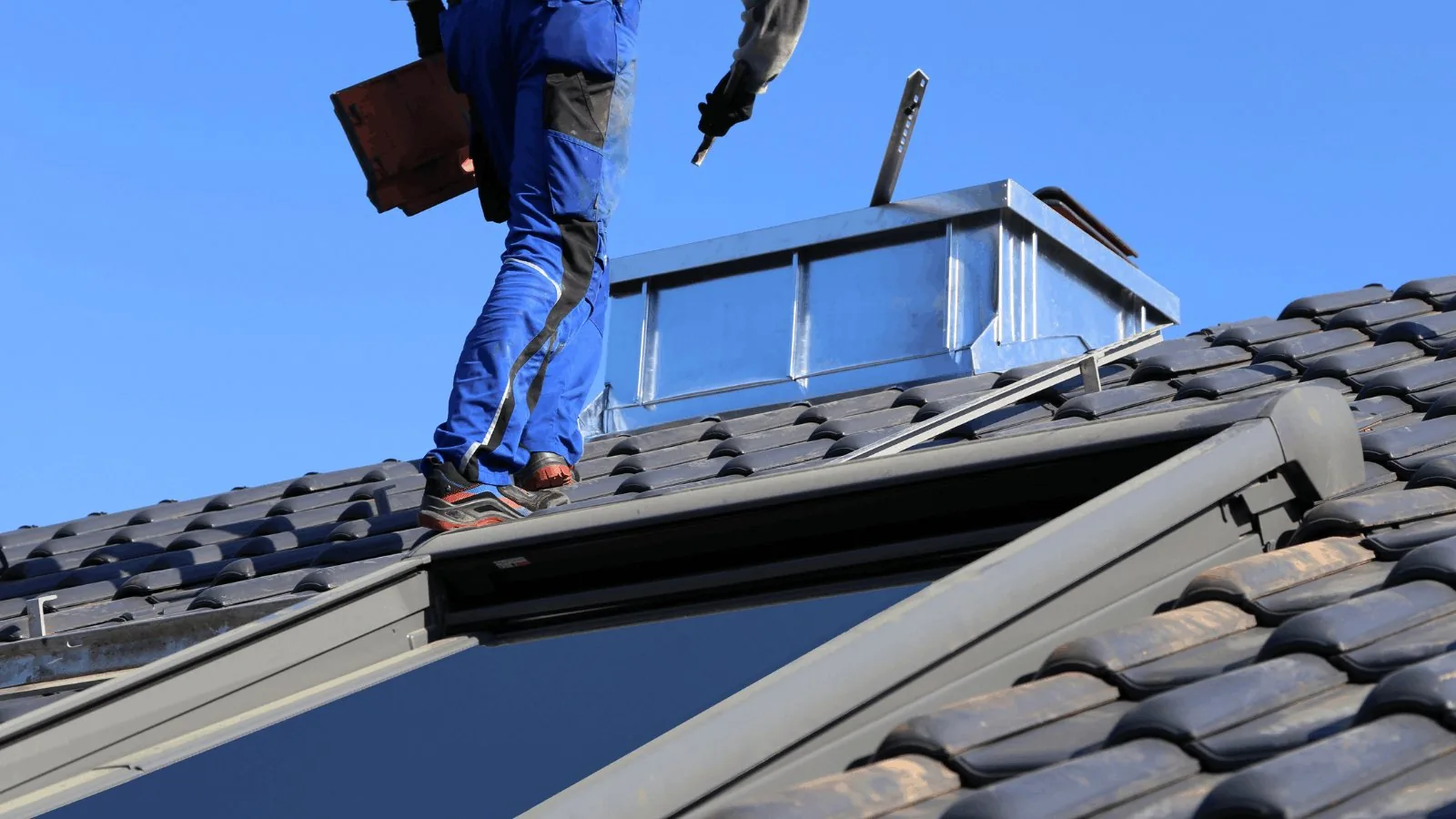 Roofer using a nail gun on a shingle roof Roofer using a nail gun on a shingle roof
